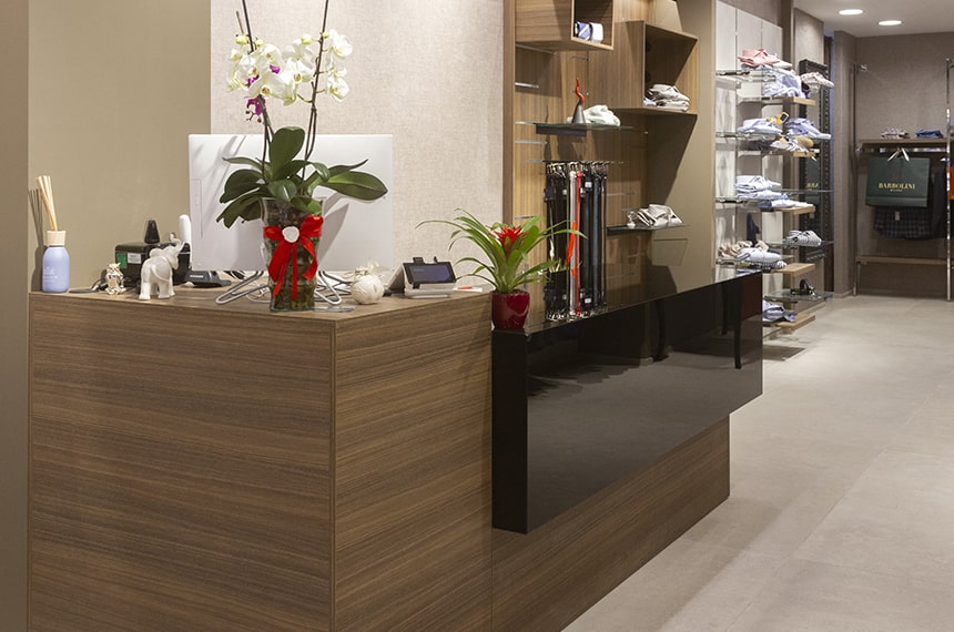 Arredamento negozio abbigliamento da uomo, dettaglio cassa personalizzata noce e nero lucido