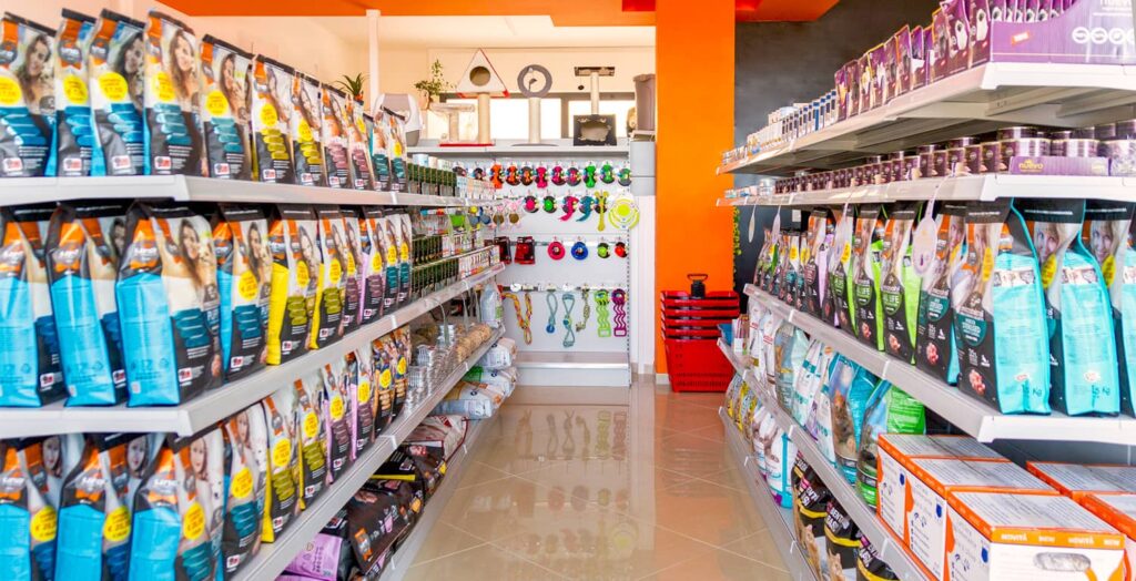 Arredamento negozio di animali: panoramica corridoio espositivo e parete accessori