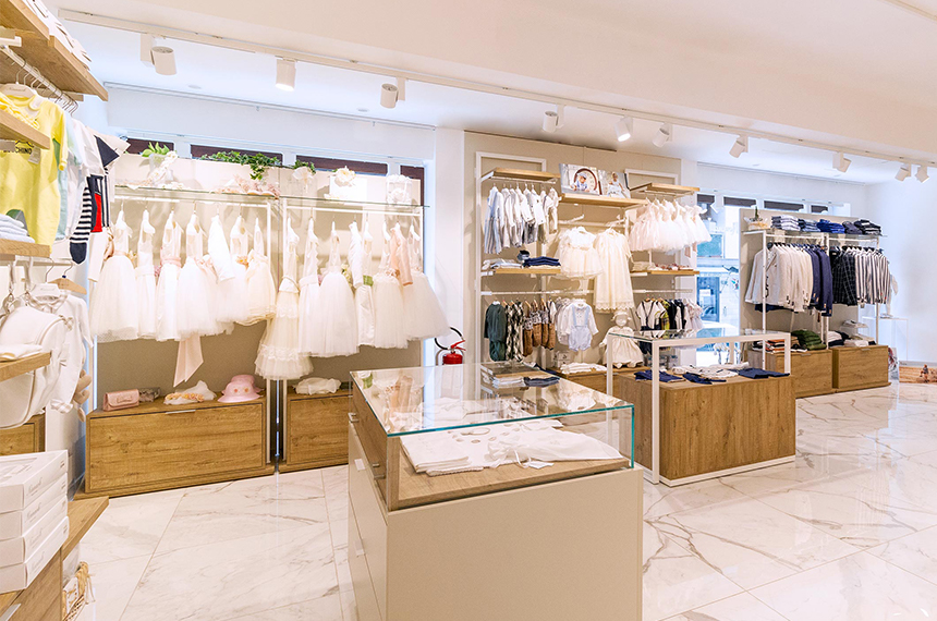 Arredamento negozio abbigliamento bambini: teca espositiva e parete modulabile con cassetti