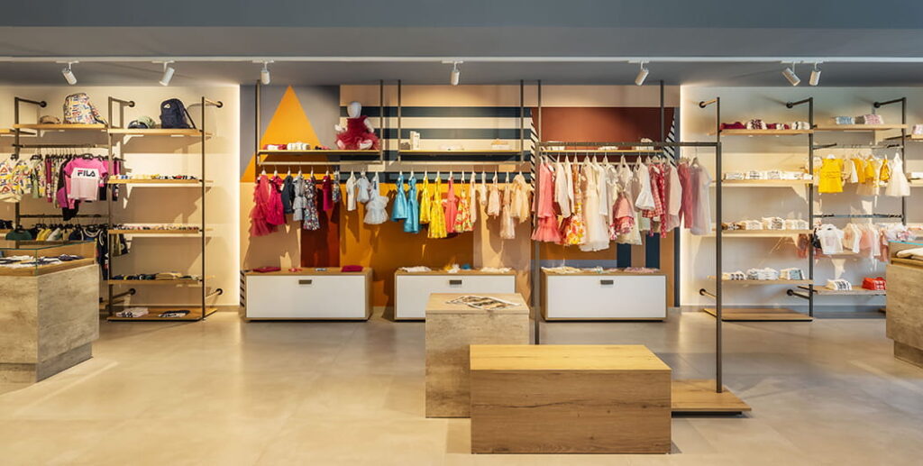 Vista su parete negozio abbigliamento bambini con personalizzazione a parete. Spettacolo Design per Rolema Noi 2 Young